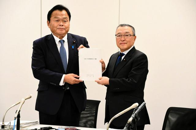 記者会見で2025年度税制改正大綱の文書を持つ自民党の宮沢洋一税調会長（右）と公明党の赤羽一嘉税調会長=2024年12月20日、国会内、中村建太撮影