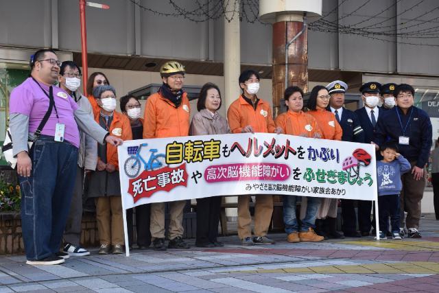 高次脳機能障害の要因の一つとなる事故の予防に向け、自転車ヘルメットの着用など訴えた当事者や家族会のメンバー＝２１日午後、宮崎市