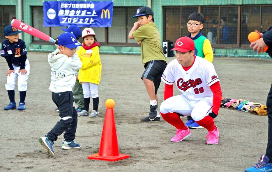 児童のバッティングを指導する羽月隆太郎選手＝小林市南西方