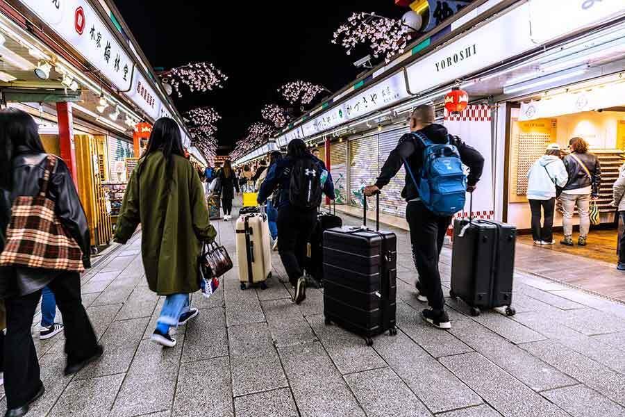 スーツケースなど大きな荷物を手に観光する外国人旅行者（写真はイメージ）【写真：PIXTA】