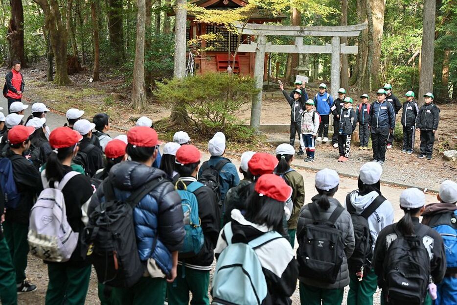 熊野古道「発心門王子」で、田辺東部小学校の児童（手前）に説明する三里小学校の児童＝５日、和歌山県田辺市本宮町三越で