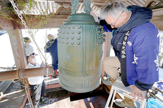 大みそかを前に山寺観光協会員らの手ですす払いが行われた立石寺の鐘楼＝山形市山寺