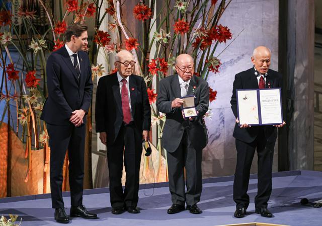 ノーベル平和賞を授与される、（右から）日本被団協の箕牧智之さん、田中重光さん、田中熙巳さんと、ノルウェー・ノーベル委員会のフリドネス委員長（左）=2024年12月10日午後1時28分、オスロ、上田潤撮影