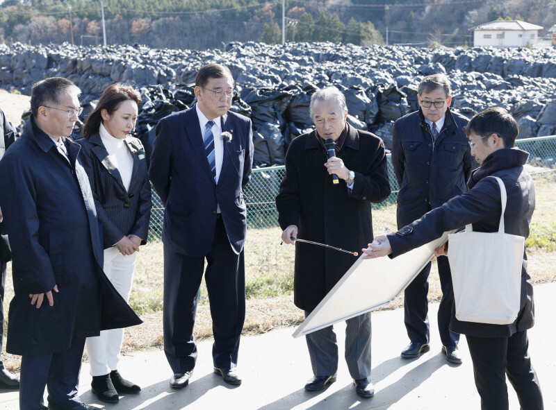 除去土壌の仮置き場を視察する石破茂首相（左から3人目）。その右は説明する伊沢史朗双葉町長＝福島県双葉町で2024年12月14日（代表撮影）