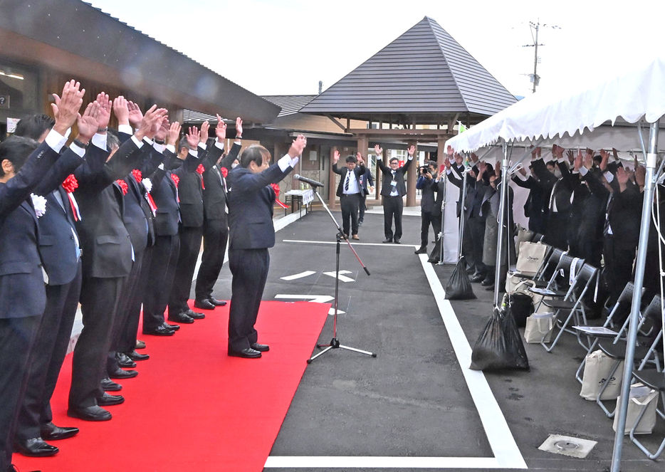 万歳三唱で施設の門出を祝った道の駅「とくのしま」のオープン記念式典＝21日、鹿児島県徳之島町花徳