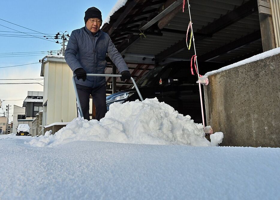 一晩で家の前に積もった雪を片付ける市民＝7日午前8時過ぎ、青森市桂木3丁目