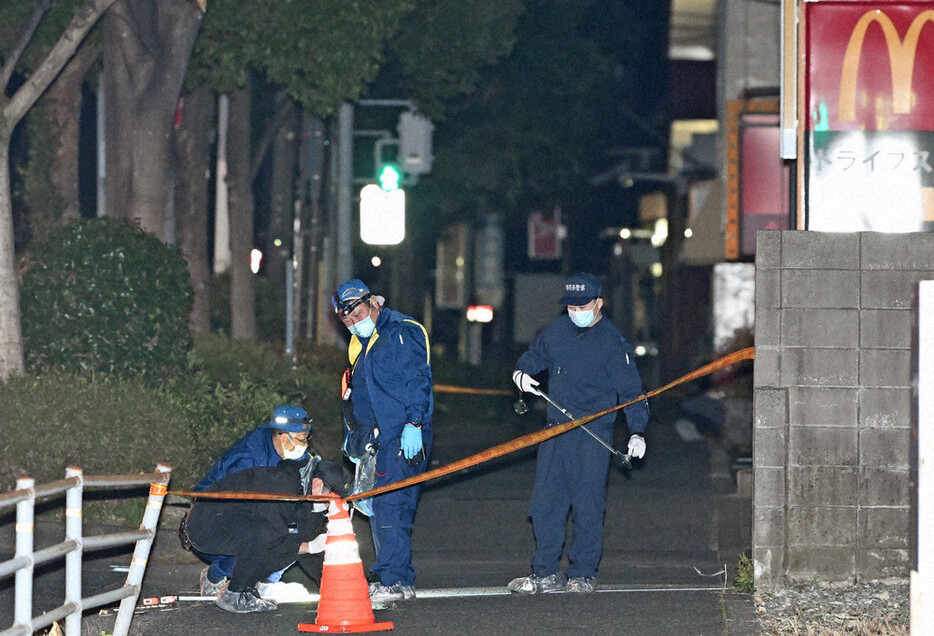 中学生２人が刺されたマクドナルド３２２徳力店の周辺を調べる捜査員ら＝北九州市小倉南区で１５日午前０時１０分、平川義之撮影