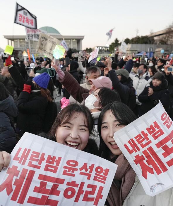 韓国の尹錫悦大統領の弾劾訴追案が可決され、国会前で喜ぶ人たち＝14日、ソウル（共同）