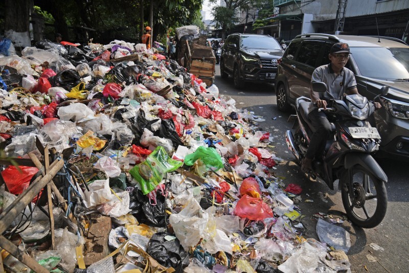 道路脇に積み上がったプラスチックなどのごみ。プラスチックが海洋など環境中に流出する最大の原因はごみの不適切な管理だという＝ジャカルタで2024年11月26日、AP