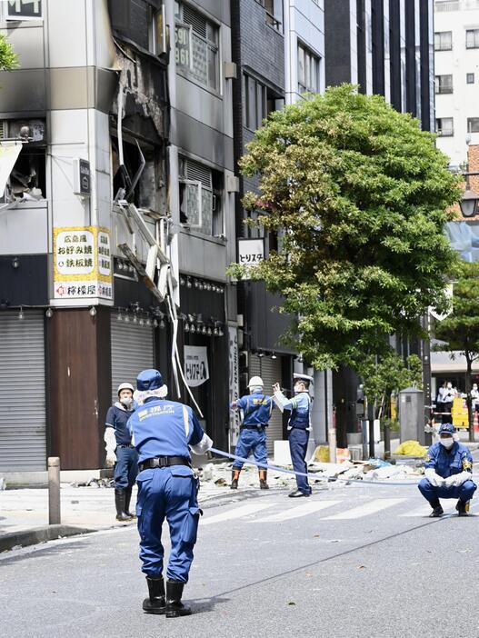 2023年7月、爆発があった東京・新橋のビル付近を調べる警視庁の捜査員ら