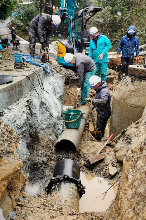 能登半島地震で破損した水道管の復旧工事に当たる作業員ら＝2024年1月15日、石川県輪島市