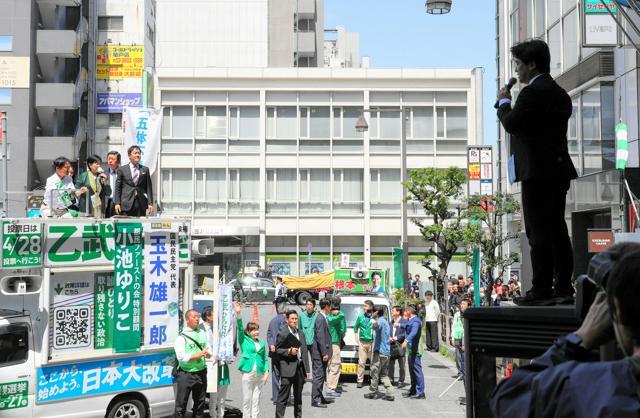 街頭演説する他の候補の前で、マイクで話し続ける政治団体「つばさの党」代表の黒川敦彦容疑者（右）。電話ボックスの上に立っていた=2024年4月16日、東京都江東区