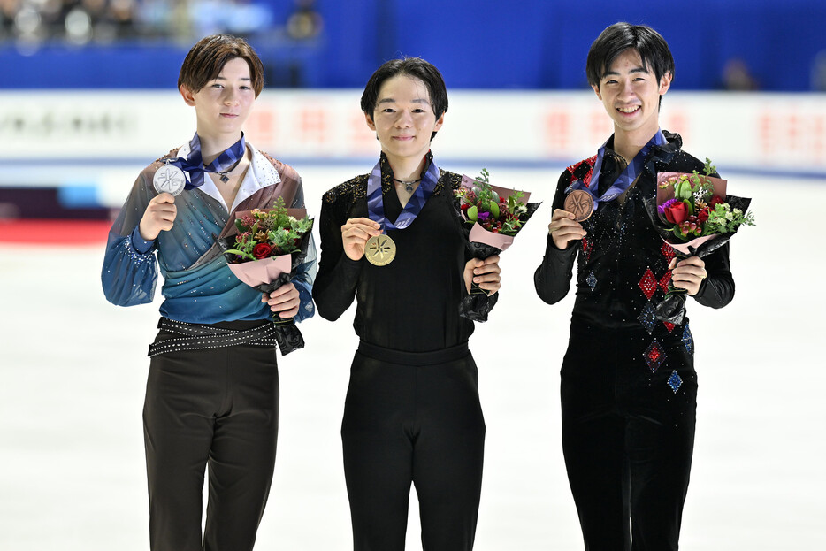 フィギュアスケートの全日本選手権男子で初優勝した鍵山優真（中央）。左は２位の中田璃士、右は３位の壺井達也＝２１日、大阪・東和薬品ラクタブドーム