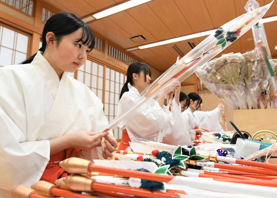 破魔矢を丁寧に袋詰めするみこ＝２８日、鳥取市国府町宮下の宇倍神社