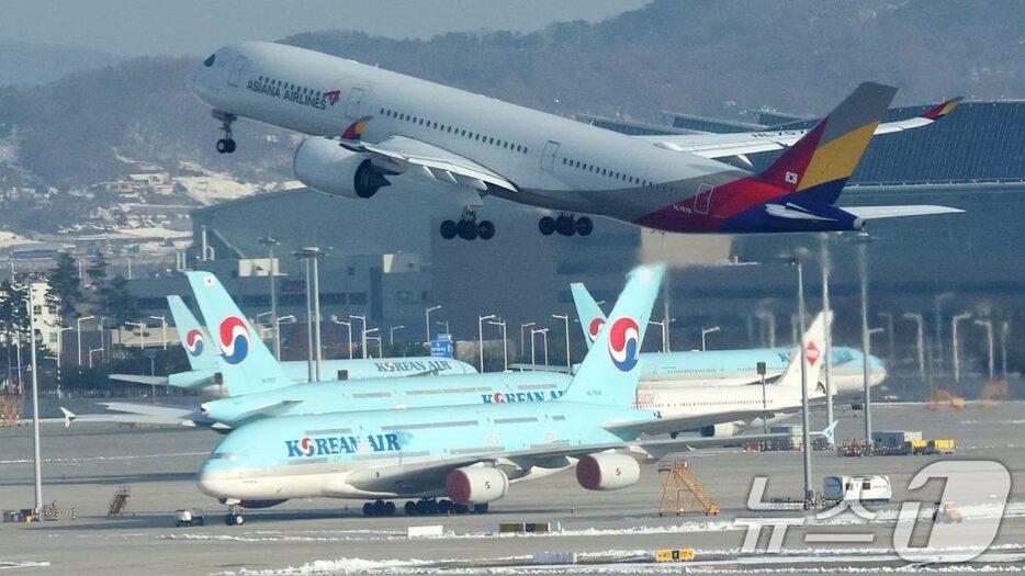 11月29日、仁川国際空港でアシアナ航空機が大韓航空機の上空を飛行する様子(c)news1