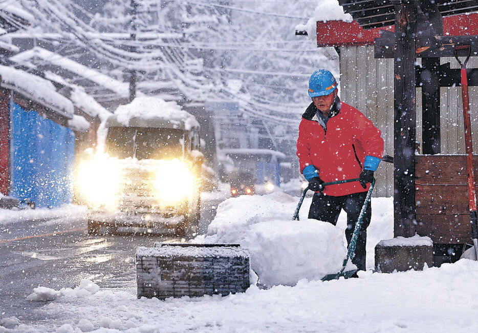 雪が降りしきる中、除雪に励む住民＝２７日午後４時半、立山町芦峅寺