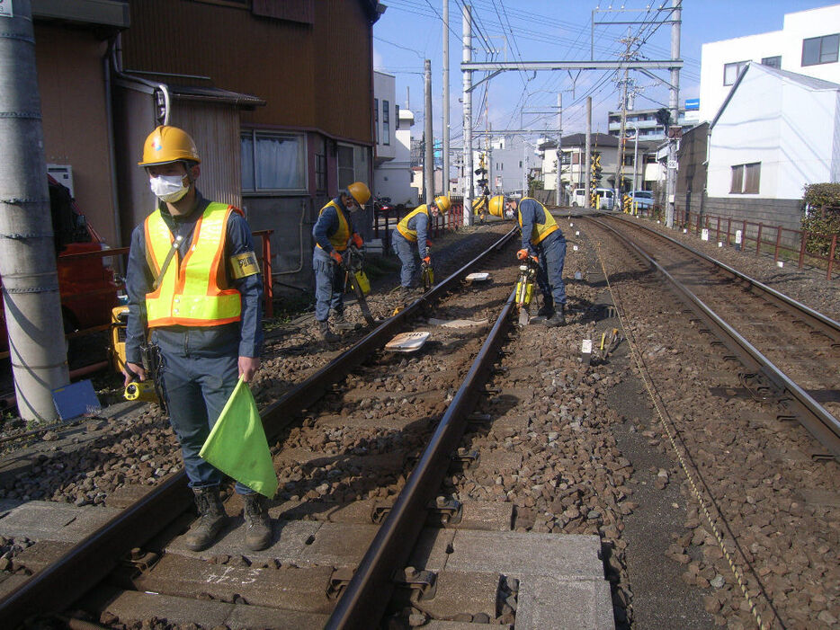 保線作業中に列車の接近を監視する見張り員（手前）。通知アプリ導入でさらなる安全確保を図る＝静岡市内