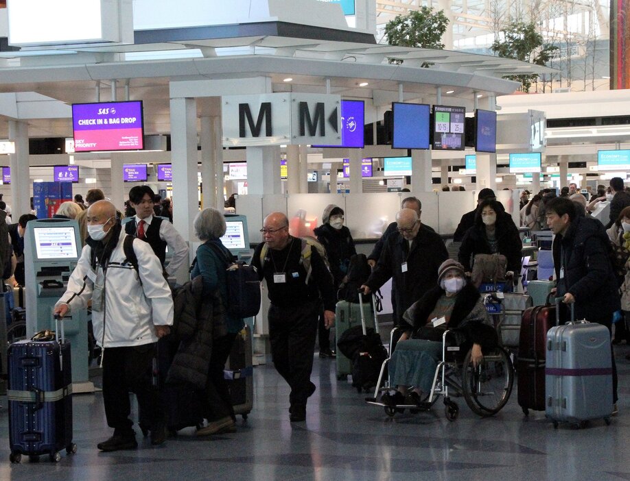 羽田空港で搭乗手続きに向かう箕牧さん（左端）たち被団協の代表団