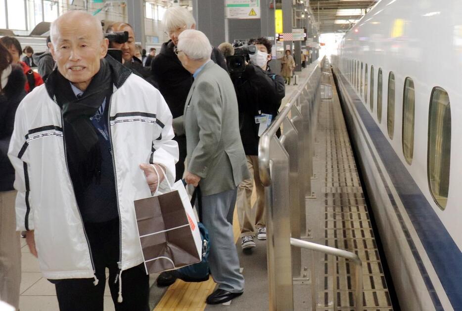 オスロに向け、広島駅で新幹線に乗り込む箕牧理事長㊧