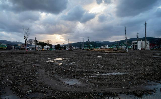 がれきが撤去され更地になった輪島朝市。夕日が水たまりを照らしていた=2024年12月31日午後4時4分、石川県輪島市河井町、伊藤進之介撮影