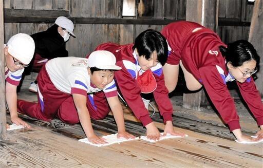 丸岡城天守内をぞうきんがけする平章小5年生=12月9日、福井県坂井市丸岡町