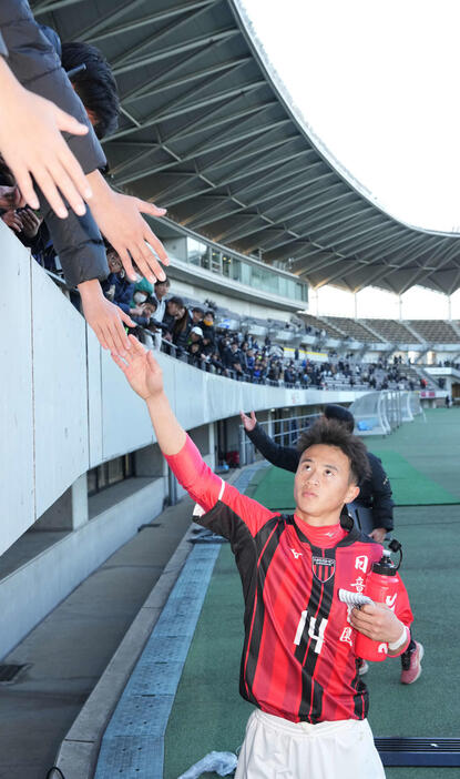 西目対日章学園　スタンドのファンとハイタッチする日章学園・高岡（撮影・小沢裕）