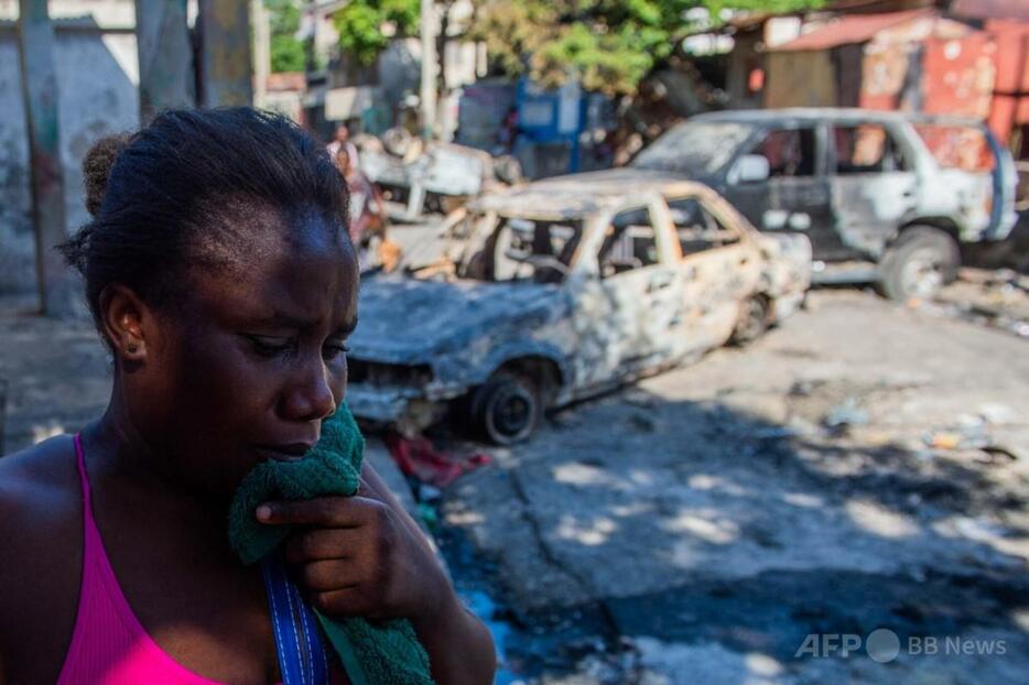 ハイチの首都ポルトープランスで、武装ギャングに夫を殺害され泣く女性（2024年12月9日撮影）。【翻訳編集】 AFPBB News