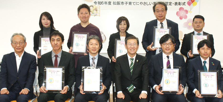 表彰状を手に写真に納まる事業所代表者と竹上市長（前列右から3人目）＝春日町一丁目で