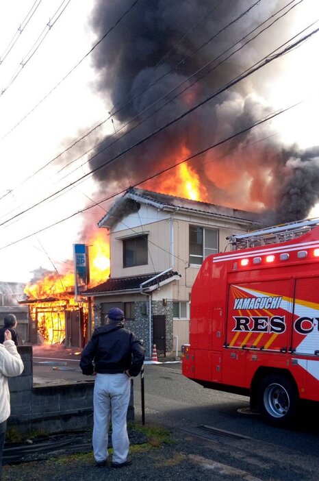 炎を上げて燃える木材店と民家（近隣住民提供）