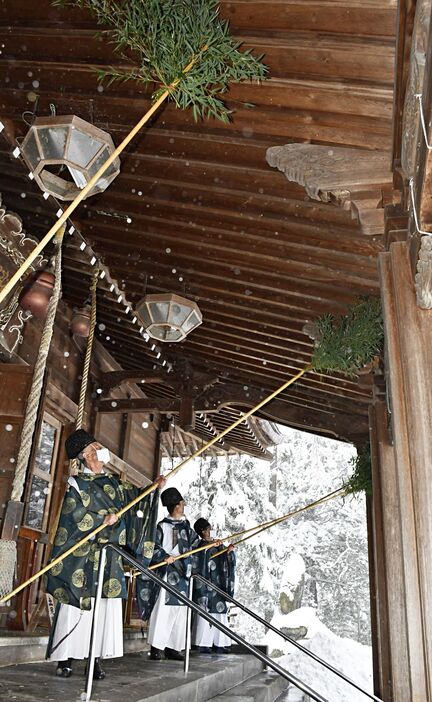 雪の中、拝殿のほこりを払う山谷宮司（左）ら神職たち