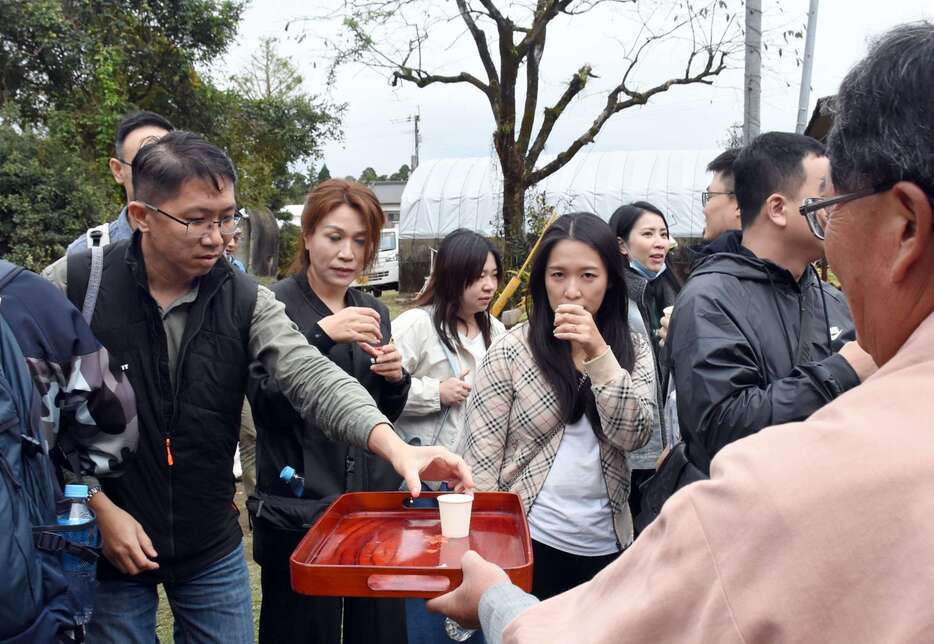 焼酎を試飲する台湾からのツアー客。県観光連盟が支援した＝１１月１９日、霧島市福山町佳例川の谷山農園