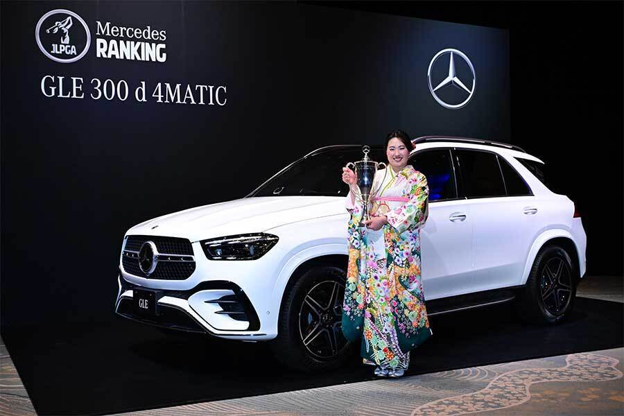 メルセデスベンツ「GLE 300 d 4MATIC」の前でトロフィーを掲げて記念写真を撮影した竹田【写真：Getty Images】