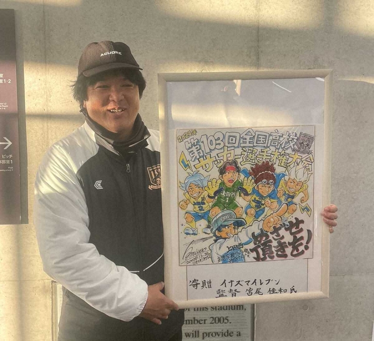 ＜上田西・徳島市立＞今大会前に宮尾佳和氏から贈呈されたアニメ「イナズマイレブン」の特別色紙を持つ上田西の白尾監督