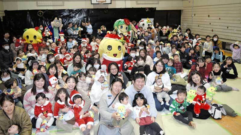 ふなっしーサンタ（中央）からクリスマスプレゼントをもらい笑顔の子どもたち＝25日、船橋市