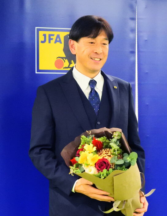 花束を受け取ったサッカーの西村雄一審判員。今季限りで第一線から勇退する＝１９日午後、東京都内