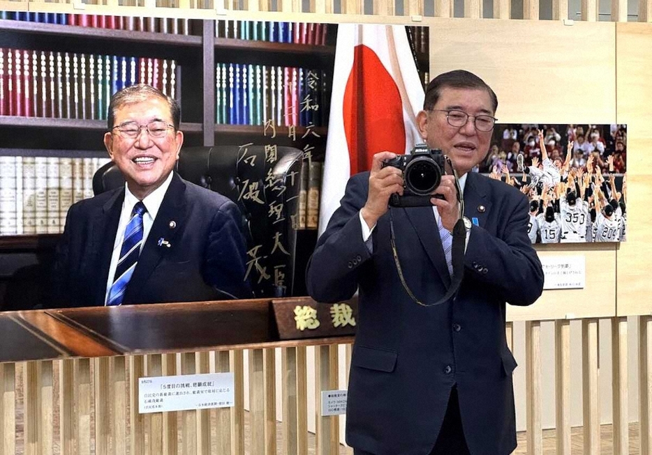 「2024年報道写真展」で、カメラを手にポーズを取る石破首相（撮影・高橋　雄二）