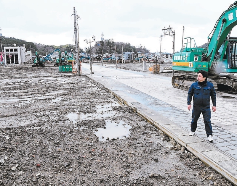 火災が発生した輪島朝市を見つめる徳野さん。重機での解体作業が進み更地になっていた＝２８日、石川県輪島市