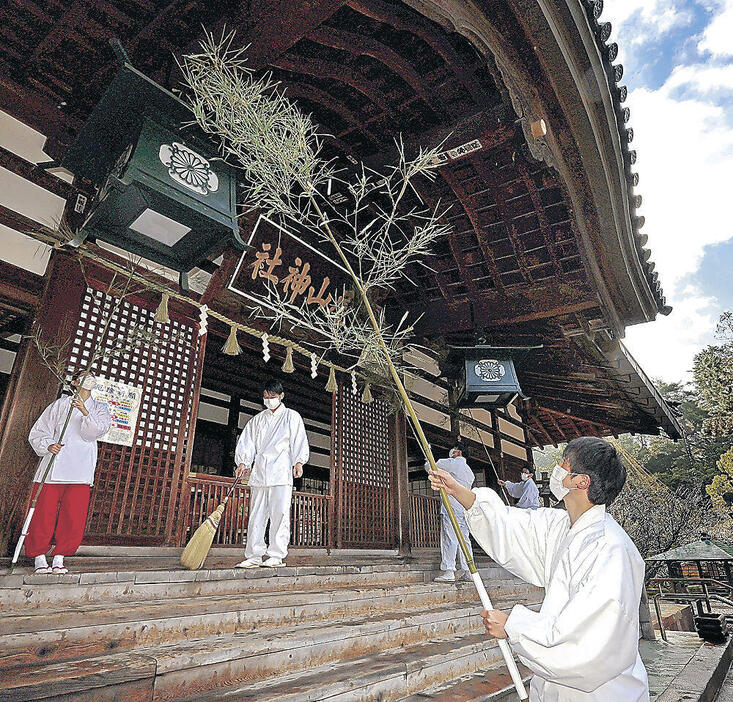 拝殿のすすを払う神職と巫女=尾山神社