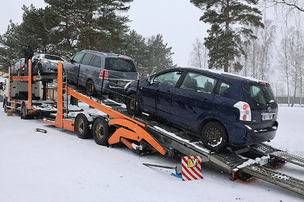 吹雪のなかカーキャリアに積まれた押収車（画像：ラトビア歳入庁）。