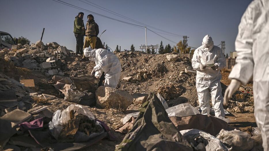 シリアのボランティア救助組織「ホワイトヘルメッツ」がダマスカスで見つかった集団墓地で遺体を収容する様子＝１６日