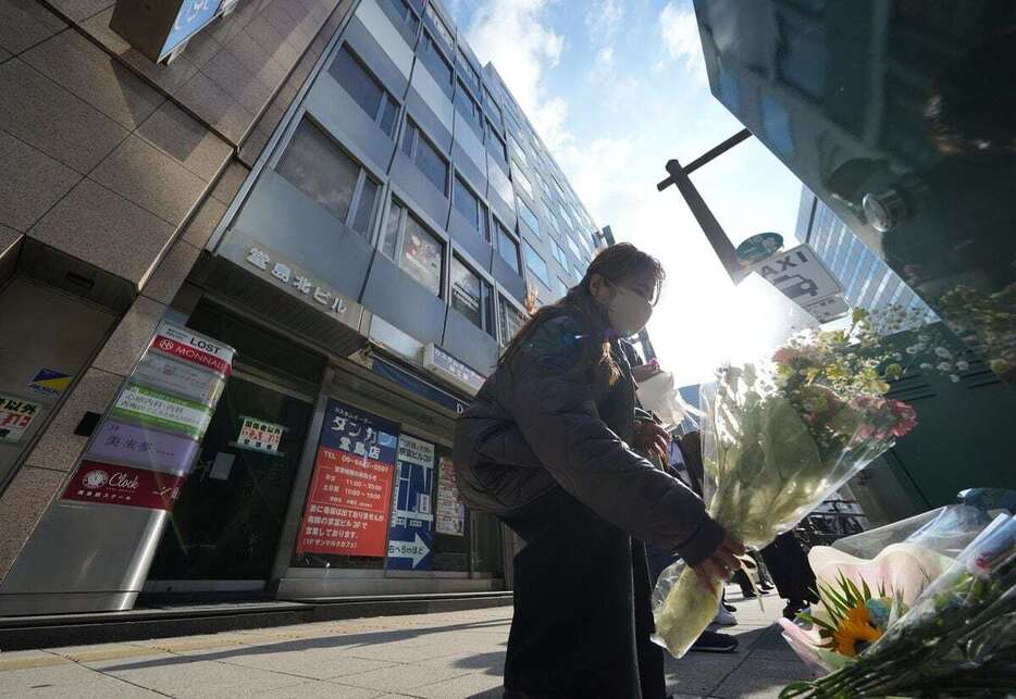 北新地放火殺人事件の発生から3年となり、事件があったビルの前で献花する人＝17日午後、大阪市北区（沢野貴信撮影）