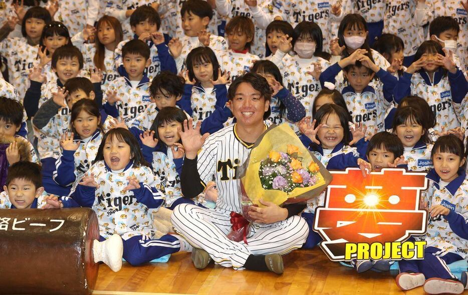 児童と記念写真におさまる阪神・村上頌樹＝賀集小学校（撮影・水島啓輔