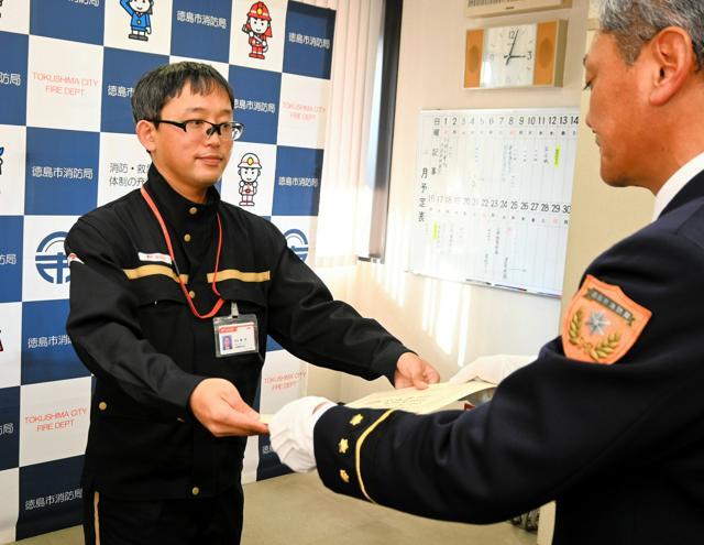 徳島市東消防署の松本弘之署長（右）から感謝状を受け取る多田嘉一郎さん=2024年12月24日、徳島市新蔵町１丁目、森直由撮影