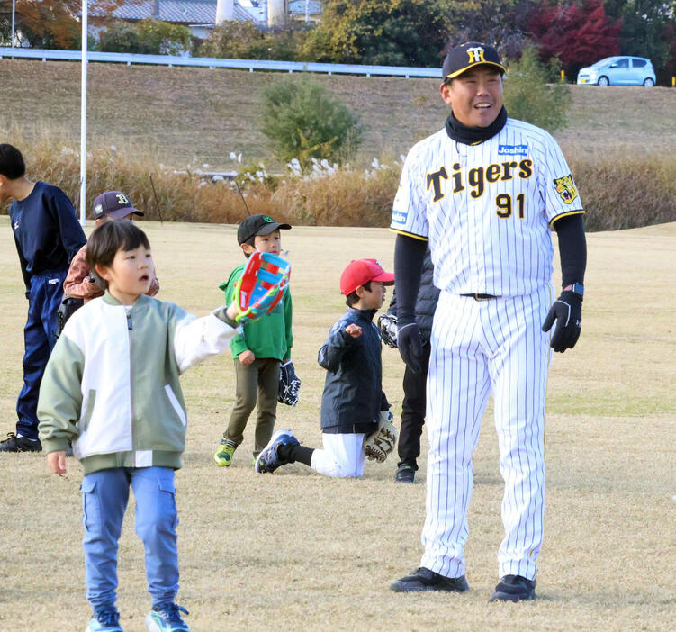 キャッチボールを行う子どもたちに指導する阪神北川2軍打撃チーフコーチ（右）（撮影・塚本光）