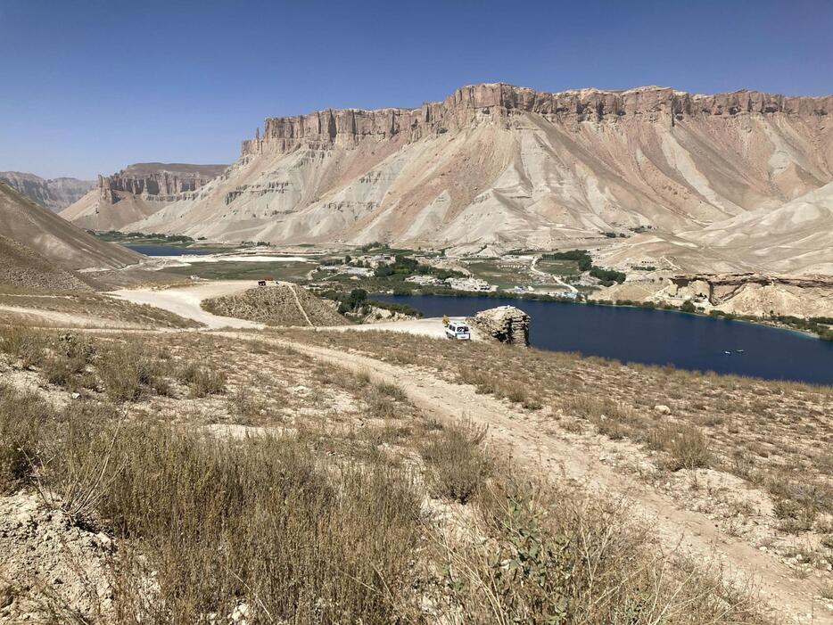 アフガニスタン中部バーミヤン近郊の山岳地帯にあるバンデアミールの拠点の湖。湖畔に宿泊施設などが並ぶ＝2024年9月（共同）