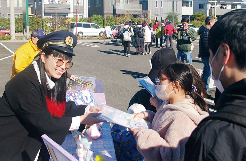 オリジナルデザインの啓発品で交通安全を呼びかけた絵子猫さん（左）（県警提供）