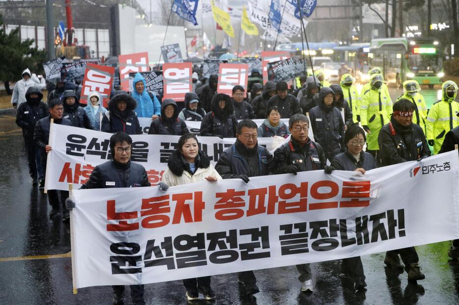 ソウル市内で韓国の尹錫悦大統領の退陣などを求めてデモ行進する人たち＝5日（共同）