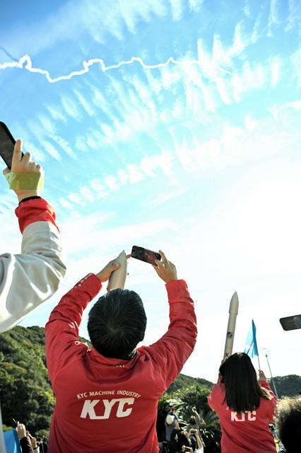 上昇を続けるカイロス2号機を見守る人たち=2024年12月18日午前11時2分、和歌山県串本町田原、菊地洋行撮影