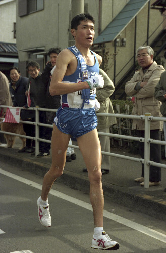 第７２回大会の４区、痛みをこらえて走る山梨学院大の中村祐二選手。無念の途中棄権となった（１９９６年１月２日）