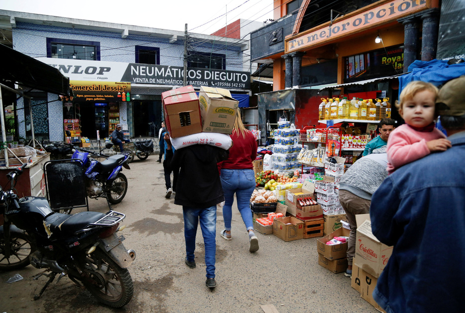 　１２月１１日、アルゼンチン国家統計センサス局（ＩＮＤＥＣ）が発表した１１月の消費者物価指数（ＣＰＩ）は、前月比２．４％上昇し、伸び率は過去４年で最低となった。写真は、アルゼンチンとの国境に近いパラグアイ・ナナワにある市場で商品を運ぶ男性。 ５月１６日撮影（２０２４年　ロイター/Cesar Olmedo）